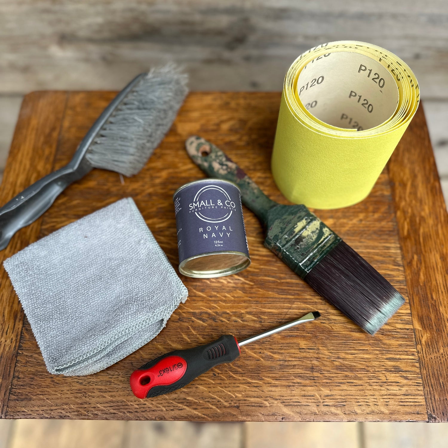 Essential furniture repair tools before painting including filler, sandpaper, paintbrush, and Small & Co chalk paint, part of beginner’s step-by-step guide to painting furniture