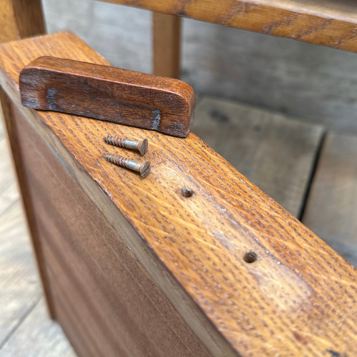 Close-up of drawer handle and screws removed before painting wooden furniture, beginner guide to prepping drawers and hardware for DIY furniture makeover