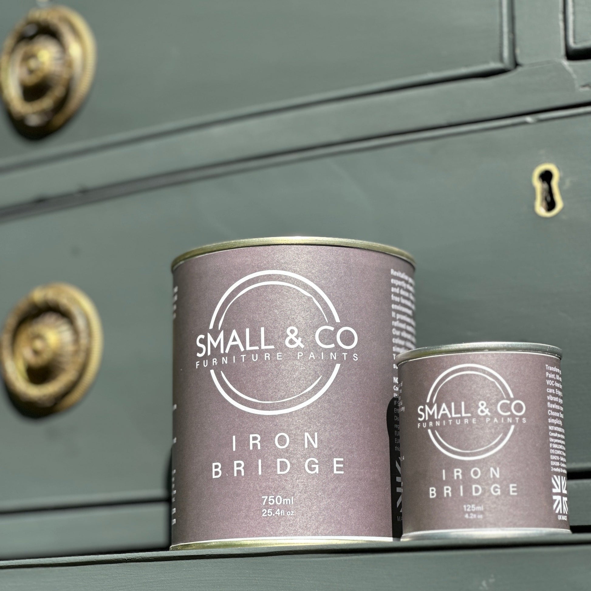 Iron bridge, dark charcoal grey furniture paint, nearly black, paint by small and co furniture paints, 750ml and 125ml tins sat side by side on a victorian painted chest of drawers