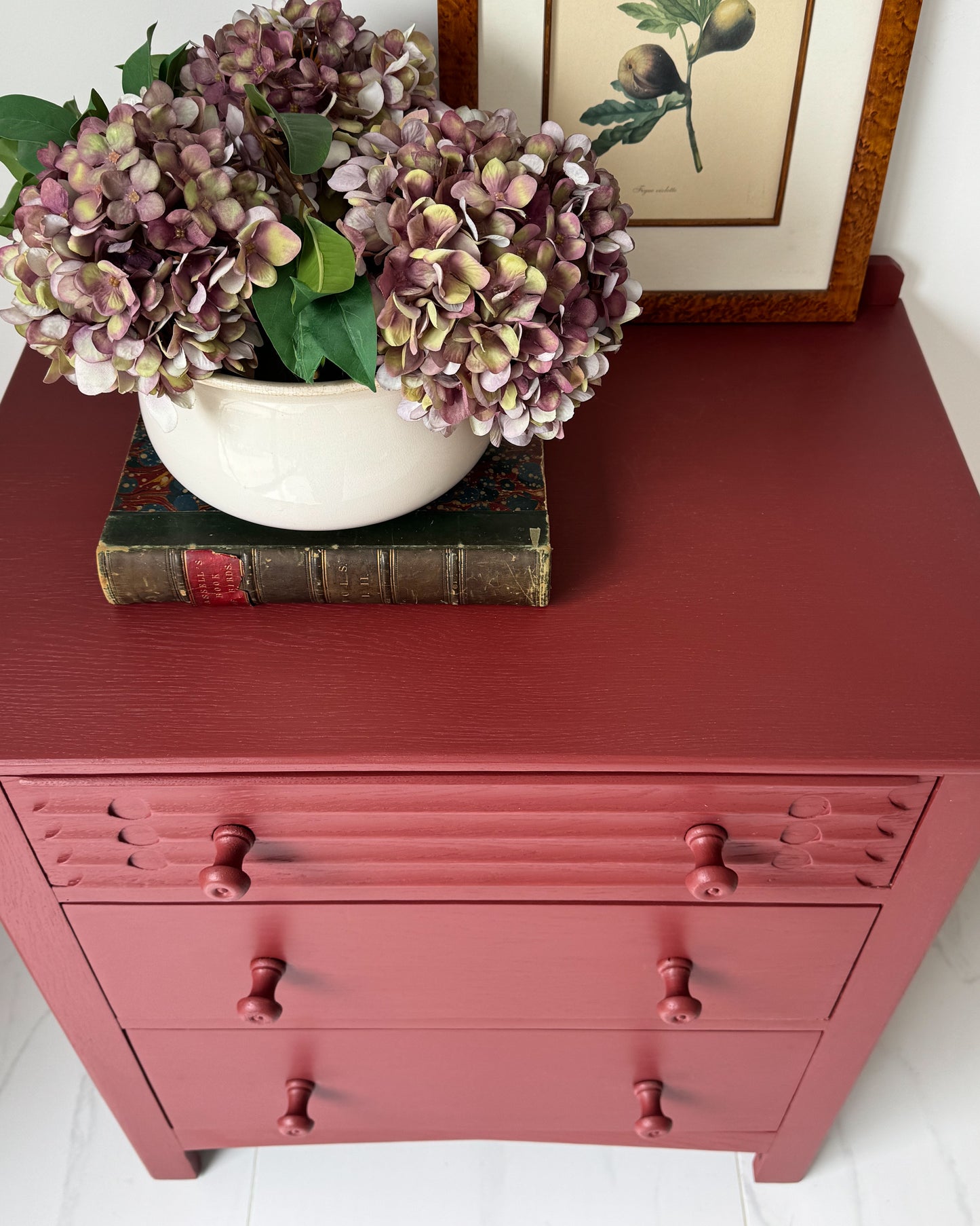 Close-up of dresser painted in eco-friendly Small & Co Cricket Leather red mineral furniture paint with decorative hydrangeas on top