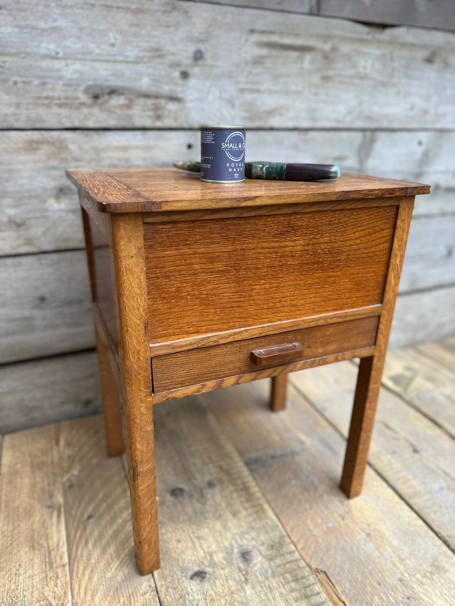 Unpainted vintage wooden side table ready for beginner furniture painting project, with Small & Co chalk furniture paint and brush placed on top, step-by-step DIY tutorial image