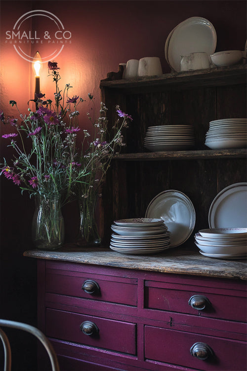 Traditional wooden farmhouse kitchen welsh dresser painted in Bedford Bramble furniture paint, styled with vintage crockery and wildflowers. Ideal for creating warm, rich interiors.